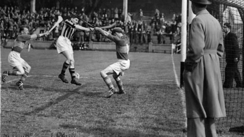 Liam Reidy scores a point in the 1950 League Final against Mick Byrne and Tony Reddan of Tipp.